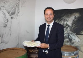 El alcalde de Serrada posa con un plato de queso.