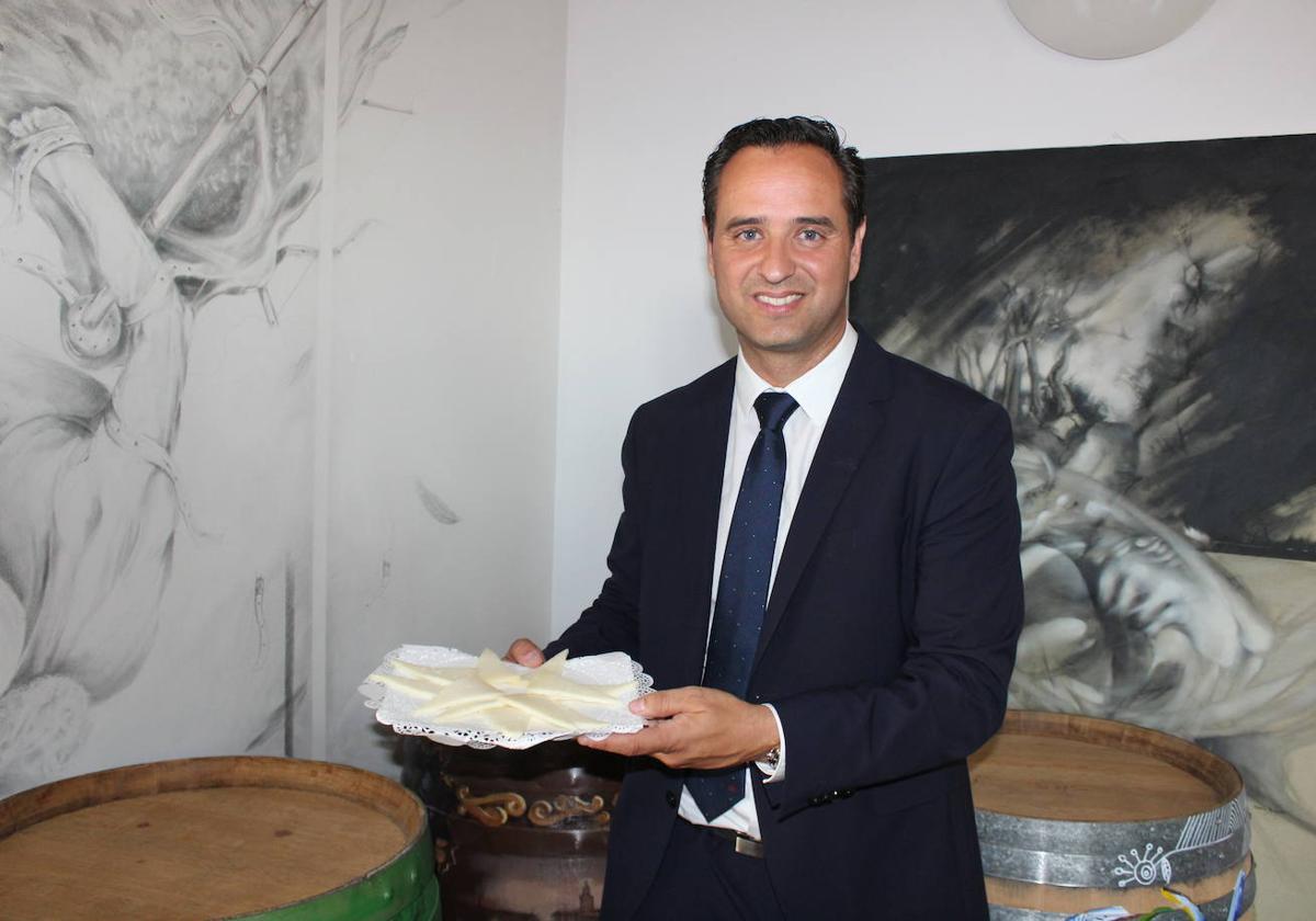 El alcalde de Serrada posa con un plato de queso.