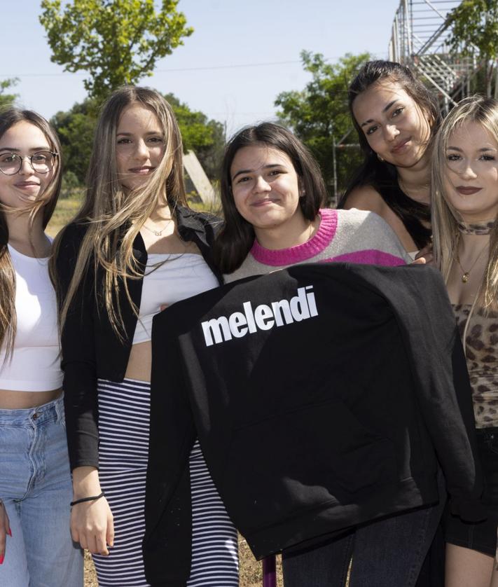 Imagen secundaria 2 - En en centro de la primera imagen, Sara Martínez, con gafas de sol, acompañada de sus amigos. El grupo al completo en la siguiente fotografía. Por último, unas fans muestra una sudadera de Melendi.