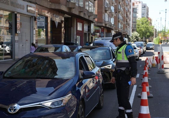 Un policía explica la situación a un conductor en el Paseo Hospital Militar, reducido a un carril.