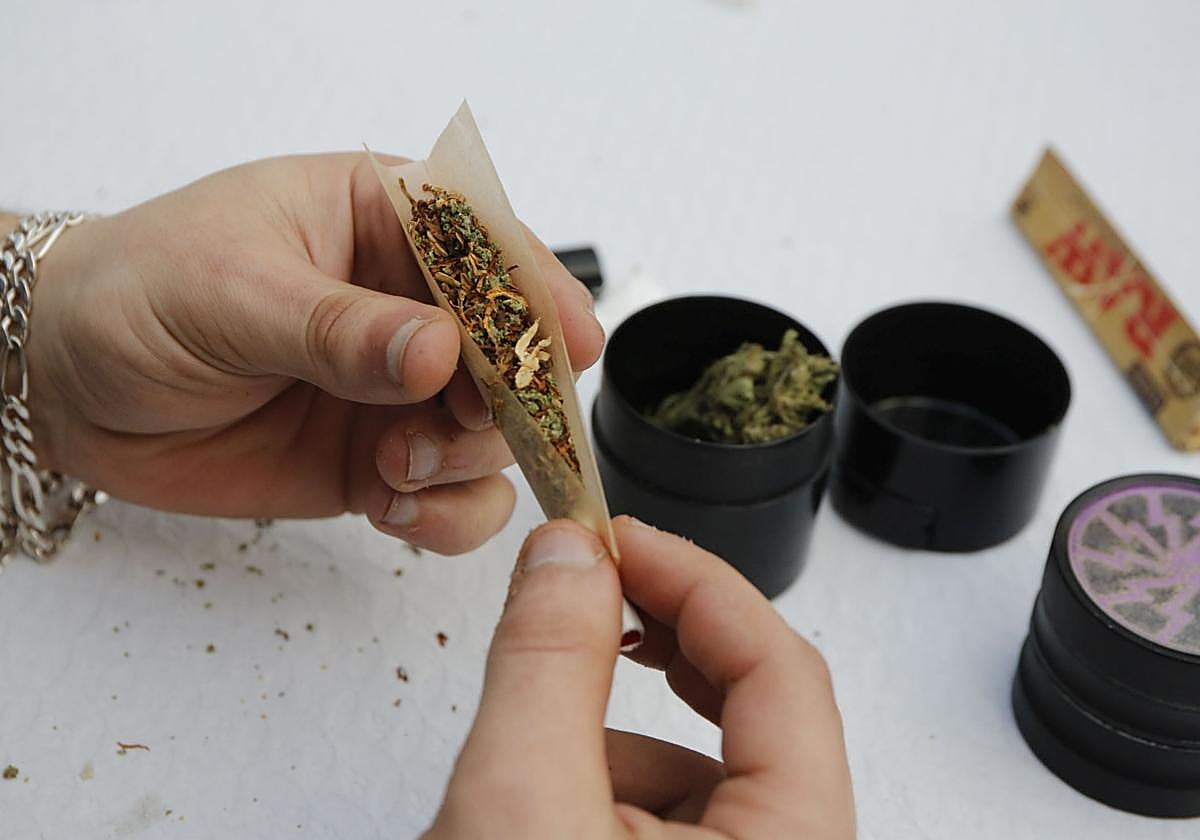 Una persona se lía un porro de cannabis.
