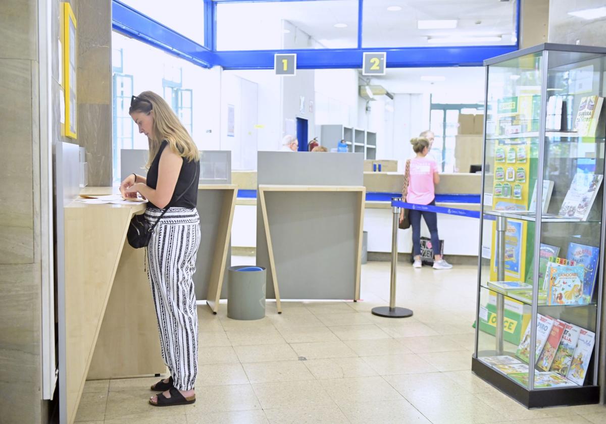 Una mujer deposita el voto por correo, en una imagen de archivo.