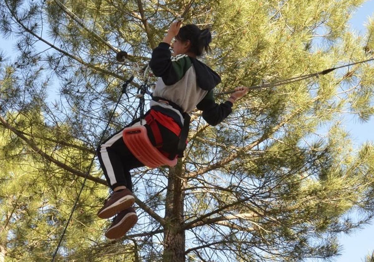 Una joven se lanza en tirolina en parque de aventuras de la provincia de Segovia.