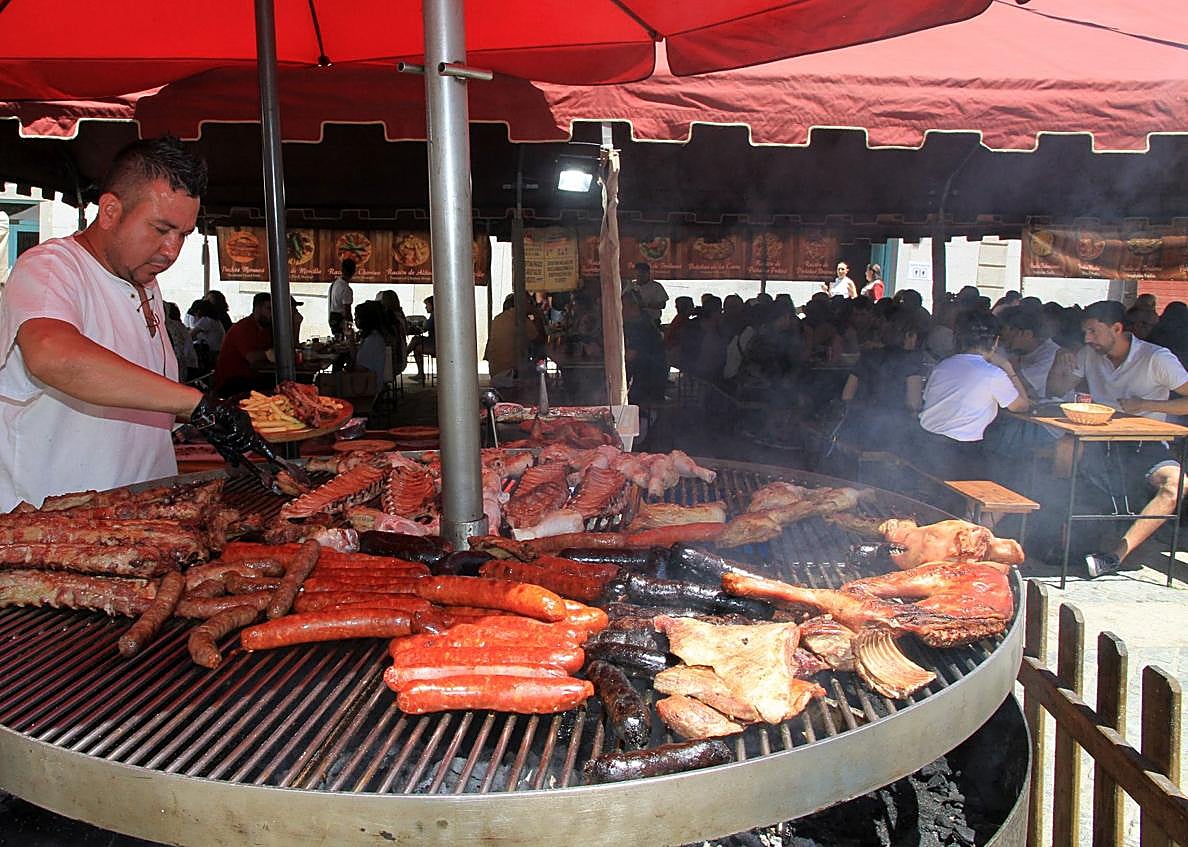 Imagen secundaria 1 - Arriba, multitud de visitantes recorren los puestos de artesanía del Mercado Barroco; abajo, uno de los puestos gastronómicos y a su derecha, una demostración de cetrería. 