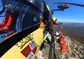El helicóptero de rescate iza al herido tras sufrir una caída en Siete Picos, este domingo.
