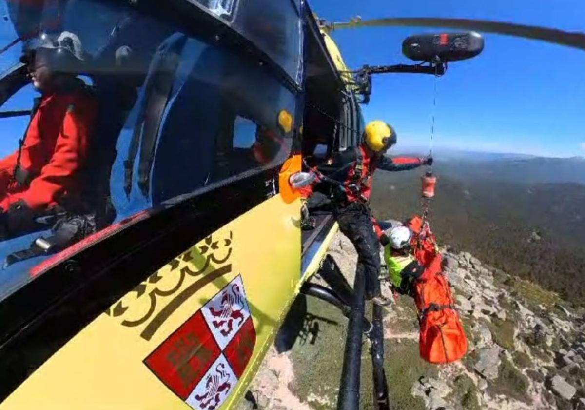 El helicóptero de rescate iza al herido tras sufrir una caída en Siete Picos, este domingo.