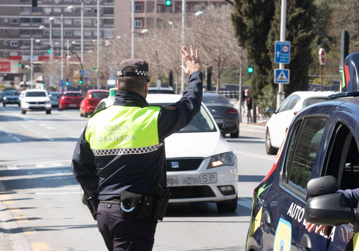 Agente de la Policía Local dando el alto a un vehículo, en imagen de archivo.