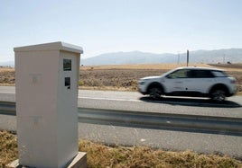 Un coche circula junto a un radar fijo instalado en la carretera N-110.