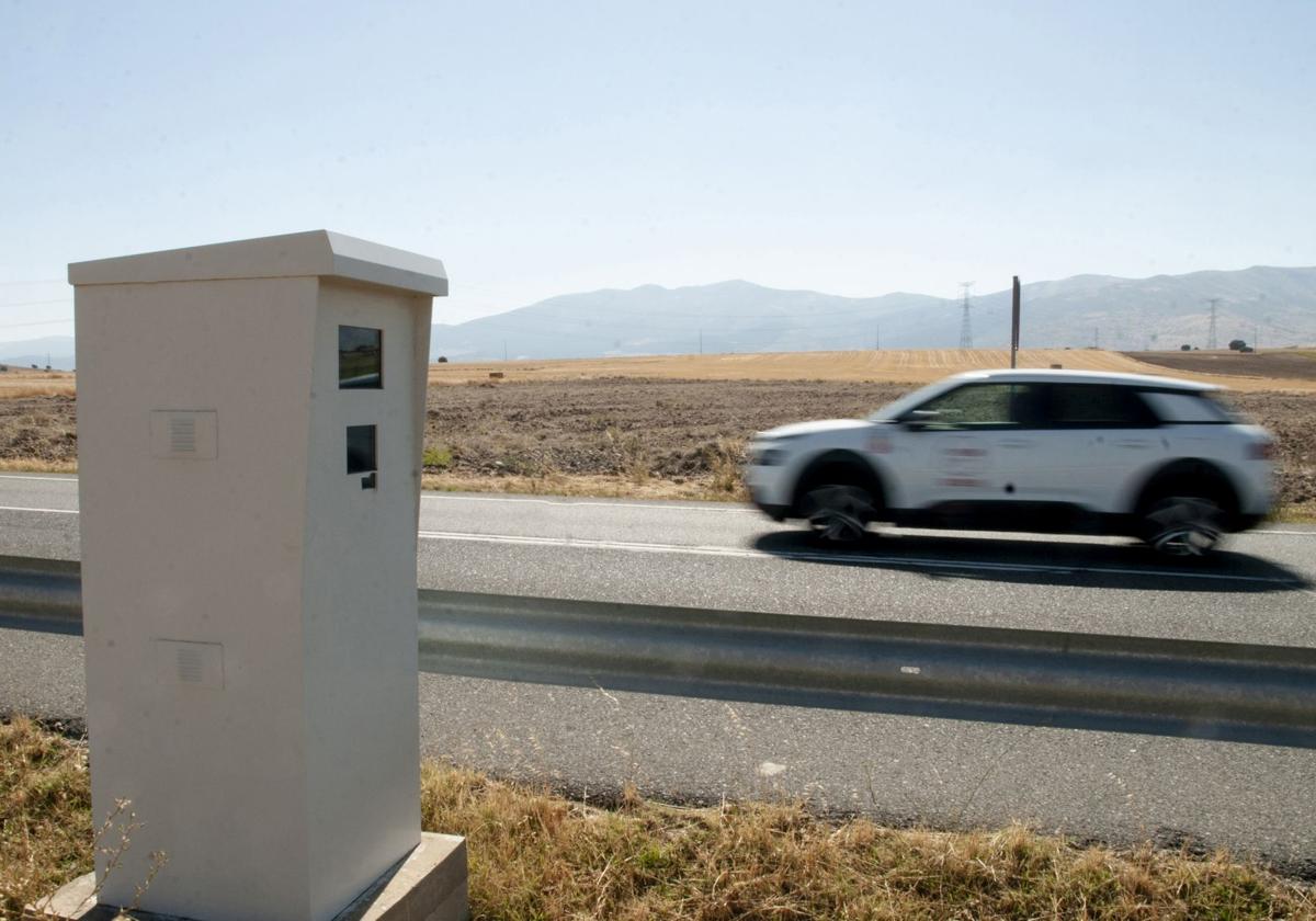 Un coche circula junto a un radar fijo instalado en la carretera N-110.