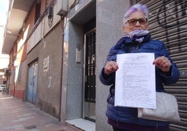 Carmen Rodríguez muestra la denuncia contra sus inquilinos a las puertas del número 1 de la calle Virgen de La Saleta de La Rondilla.