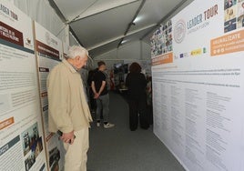 Un visitante de la exposición en la carpa del Salón observa los paneles explicativos de los proyectos.