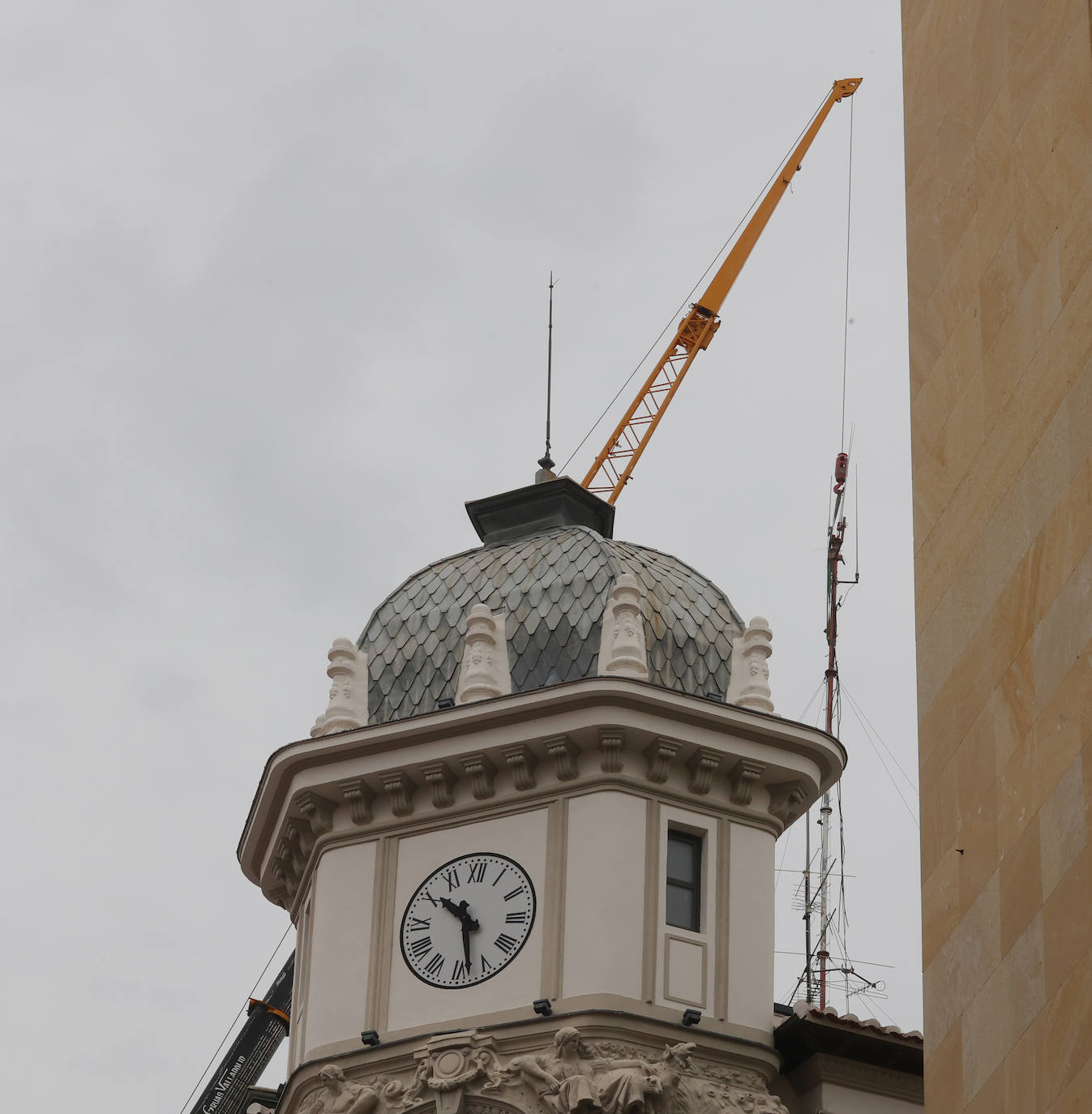 Una enorme grúa retira una antena en la Calle Mayor