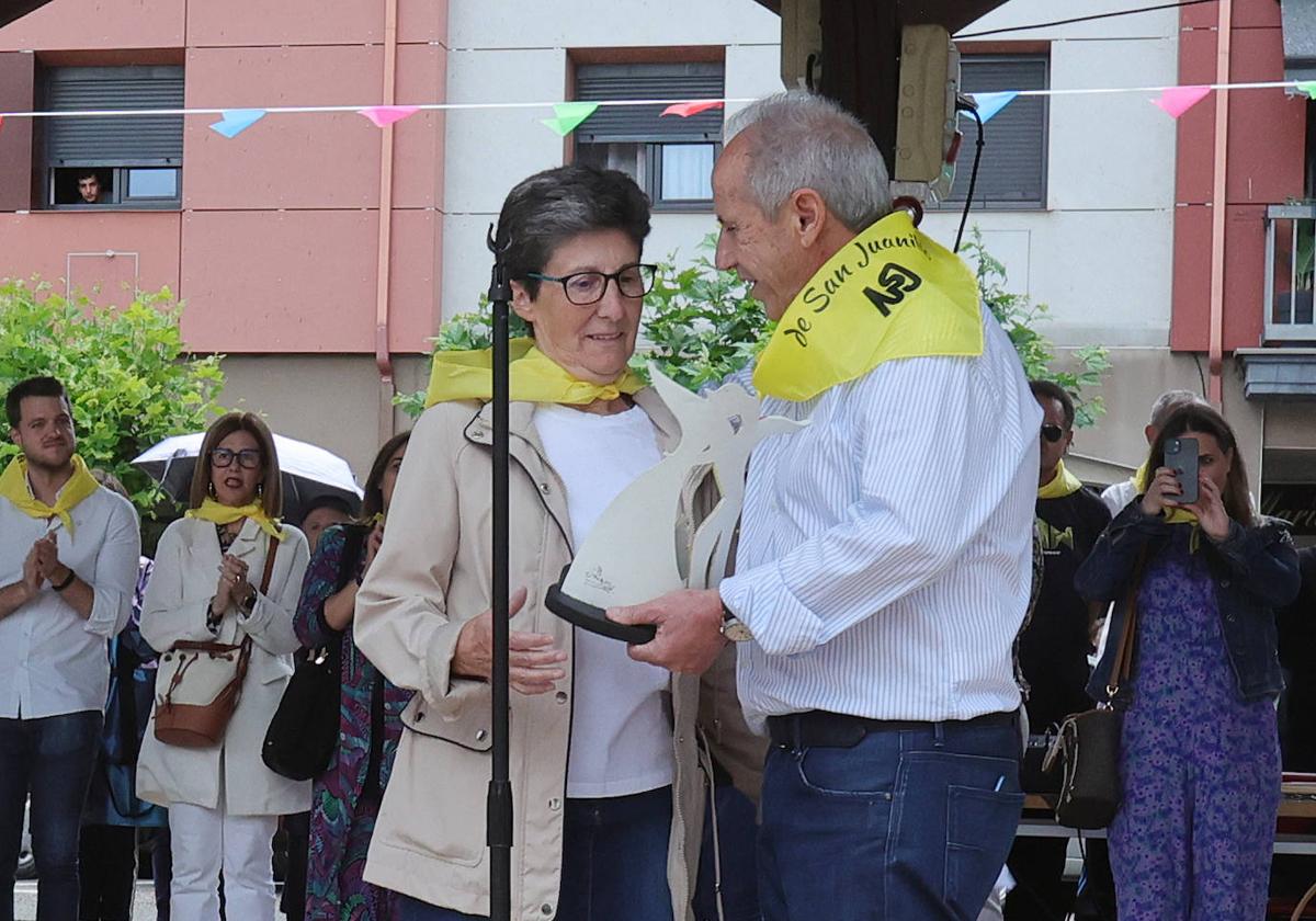 El presidente de los vecinos, Rafael Marcos, entrega el premio a la directora del centro, Lourdes Millán.