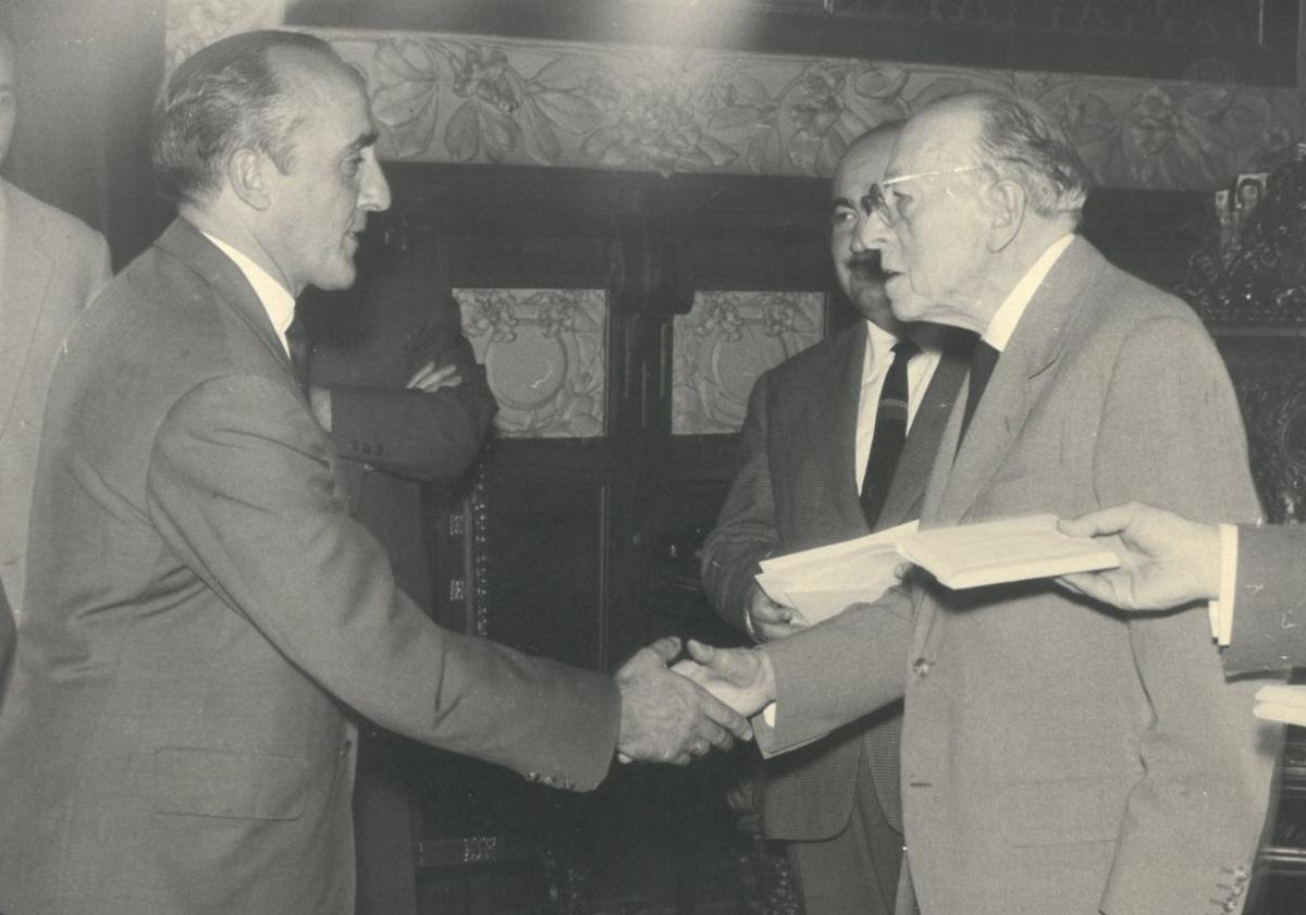 Imagen principal - Pedro Adrados (a la izquierda) recibe una distinción observado por el entonces alcalde de Valladolid, Santiago Pérez. Abajo, plano de la reforma de los escapares que Joaquín Fererro Martín hizo en 1946. A la derecha, fotografía del edificio del comercio en los años setenta.