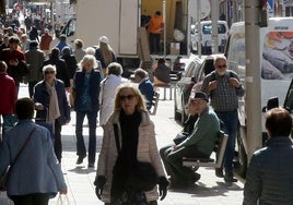 Multitud de personas pasean por una céntrica calle de la ciudad de Segovia.