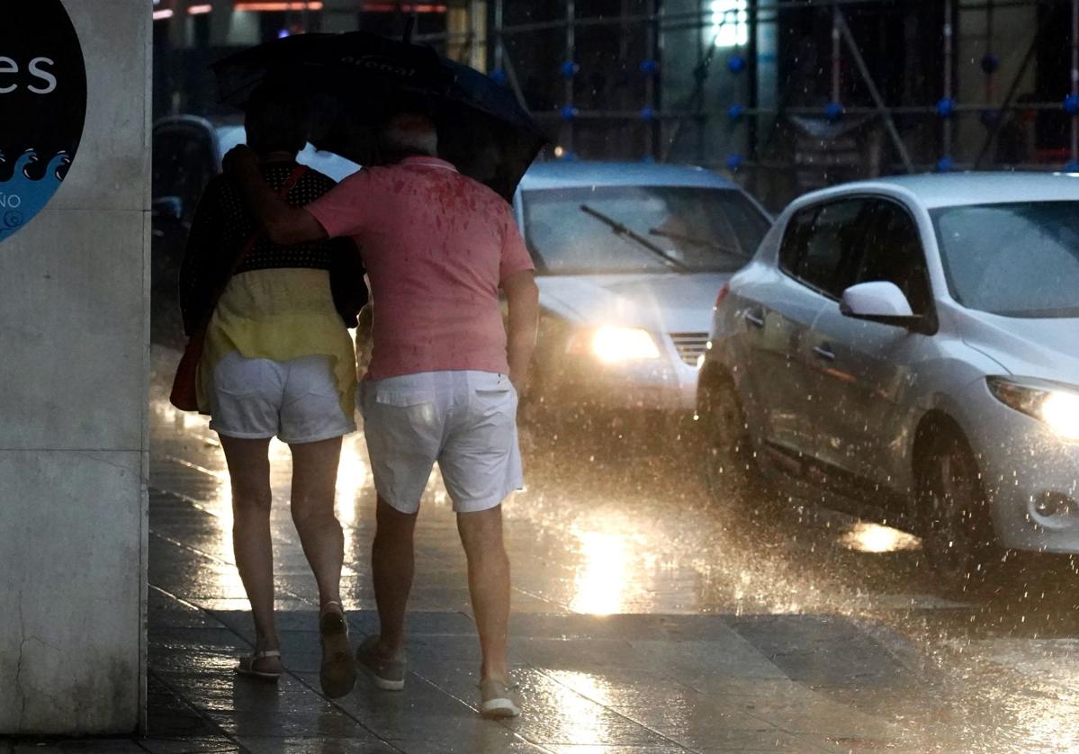 Una pareja se protege de la tormenta en León, este miércoles.