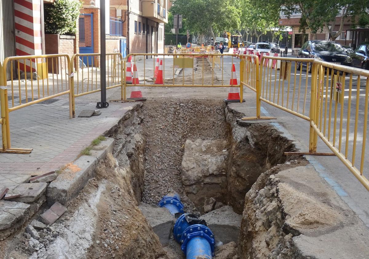 Imagen principal - Arriba, detalle de la tubería, ya colocada, que salva los restos del muro del convento. Debajo, a la izquierda, los operarios durante las obras. A la derecha, el muro antes de ser tapado.