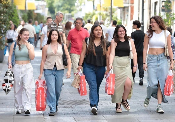 Cinco jóvenes con bolsas este jueves de rebajas en la calle Santiago de Valladolid.