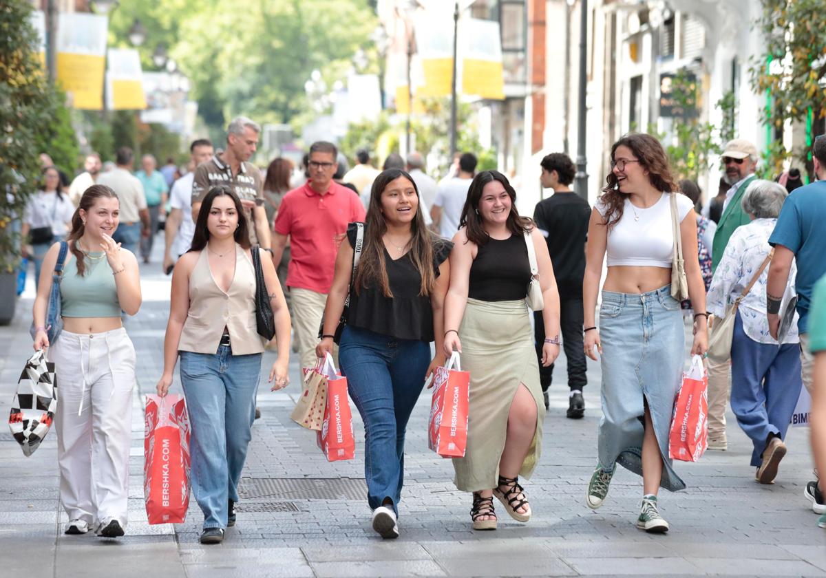 Cinco jóvenes con bolsas este jueves de rebajas en la calle Santiago de Valladolid.