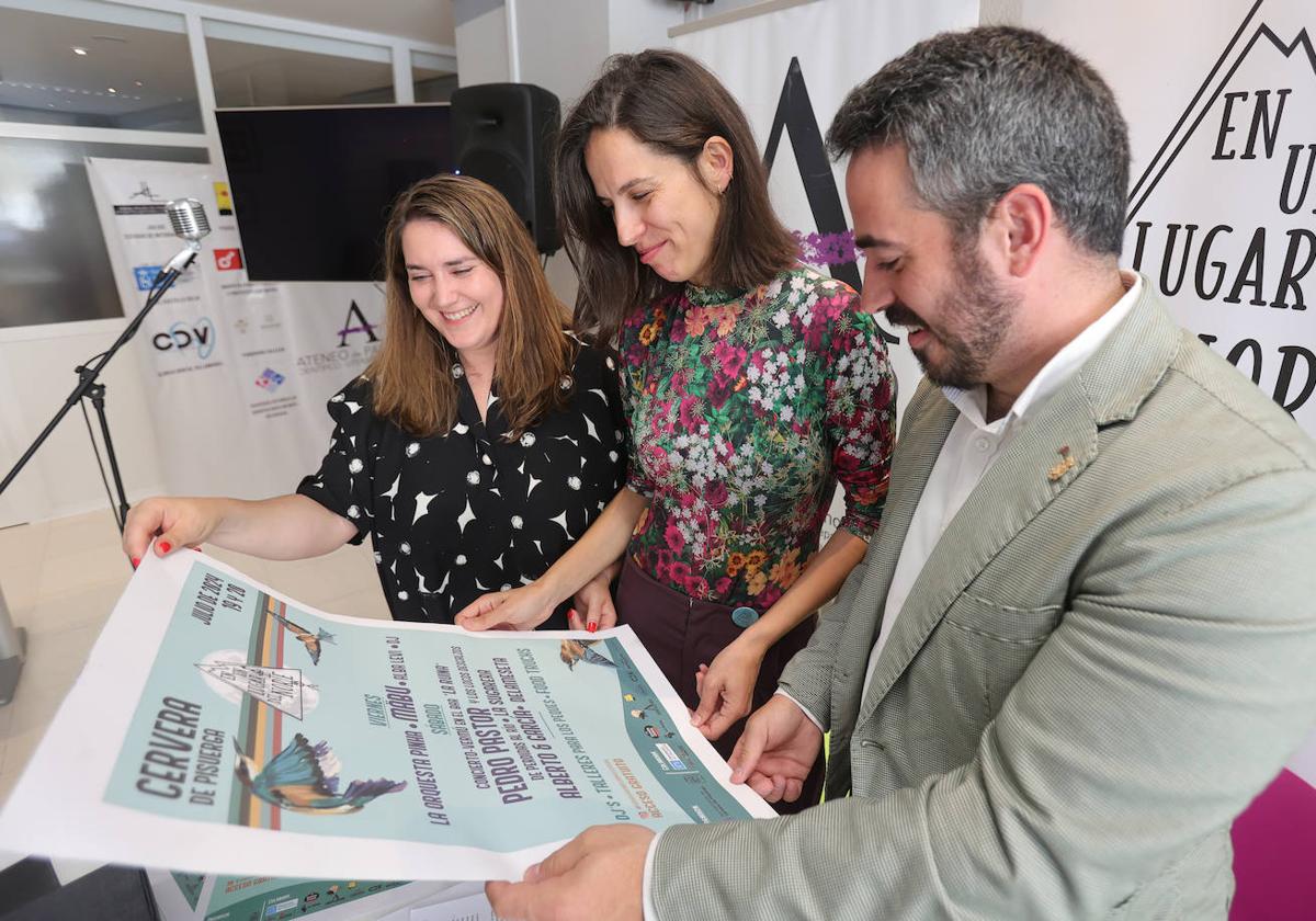 Marta Martínez, Alba Castrillo y Jorge Ibáñez observan el cartel del festival en el Ateneo de Palencia.