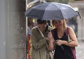 Dos mujeres se protegen de la lluvia durante una tormenta que descargó el pasado verano en Valladolid.