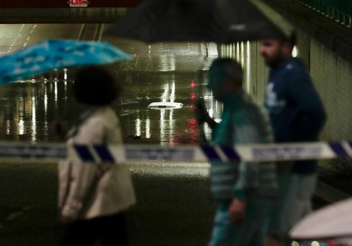 El túnel de la Circular cortado, este viernes por la noche, con un coche atrapado bajo el agua.