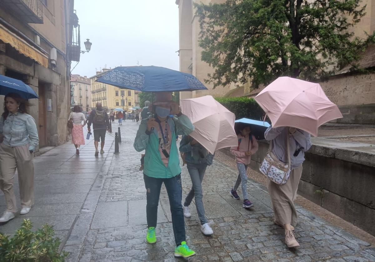 Chubasqueros y paraguas para protegerse de la lluvia, este sábado, en Segovia.