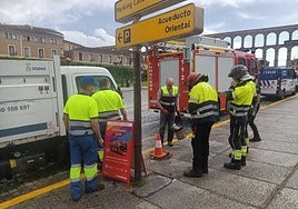 Bomberos del parque de Segovia y operarios municipales aseguran el lugar del accidente este domingo.