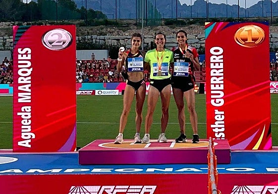 Águeda Marqués, a la izquierda de la imagen, muestra su medalla en el podio.