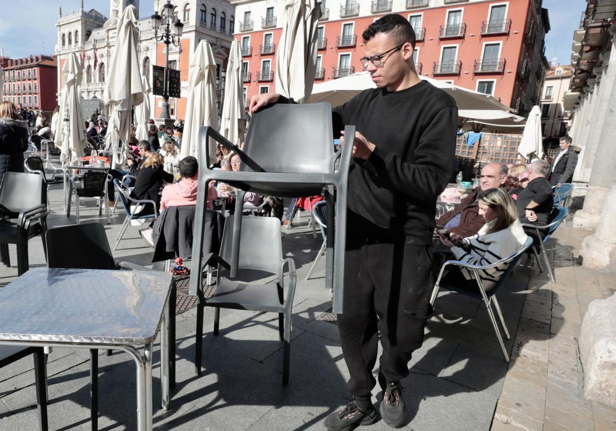 Un camarero coloca la terraza en la Plaza Mayor de Valladolid.