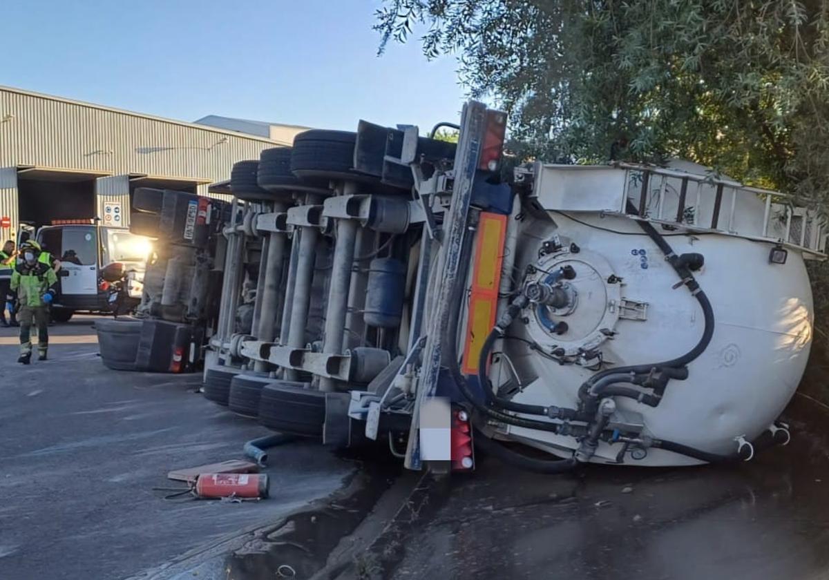 Los servicios municipales y de emergencias trabajan junto al camión volcado.