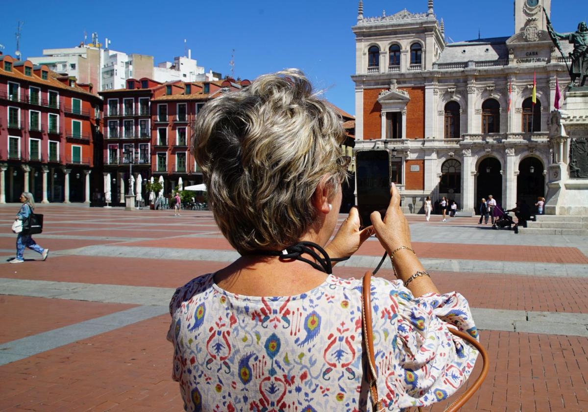 Una mujer toma una fotografía de la Plaza Mayor de Valladolid.