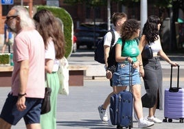 Tres jóvenes con maletas atraviesan la plaza de Zorrilla de Valladolid esta pasada semana.