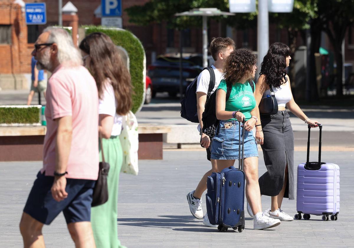 Tres jóvenes con maletas atraviesan la plaza de Zorrilla de Valladolid esta pasada semana.