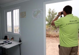 Bernardo González, vigilante en Valdesimonte, observa a través de sus prismáticos.