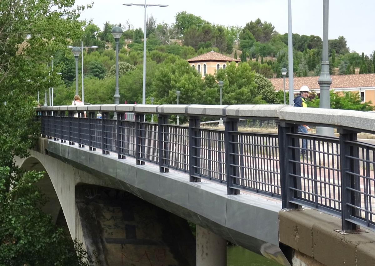 Imagen secundaria 1 - Arriba, colocación de las chapas en la margen derecha del puente hacia Parquesol. Debajo, a la izquierda, detalle de los remates ya colocados en el otro lateral. A la izquierda, las escalinatas del puente.