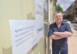 José Luis Serrano, junto su tienda de la calle Falla, con el cartel de agradecimiento a los vecinos.