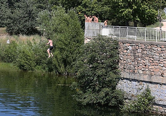 Un grupo de jóvenes realiza saltos desde el entorno de la CL-601 hasta el Pontón Alto.