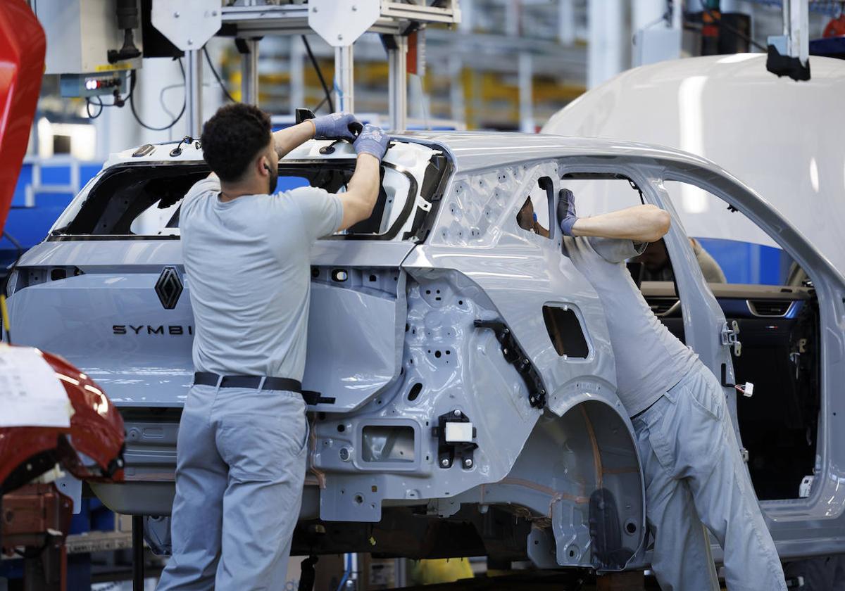 Operarios de la fábrica de Renault en Valladolid ensamblan un Symbioz, el nuevo modelo híbrido de la marca.