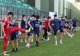 Jugadores de la Segoviana realizan estiramientos al inicio del entrenamiento.