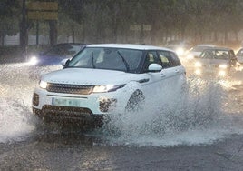 Automóvil circulando bajo lluvia intensa, en imagen de archivo.