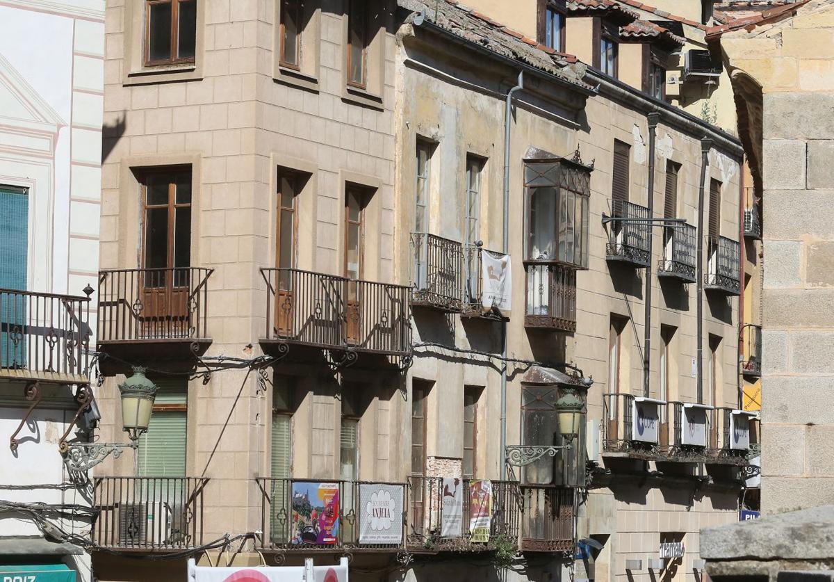 Bloques de edificios antiguos rehablitados y otros sin reformar en la Calle Real de Segovia.