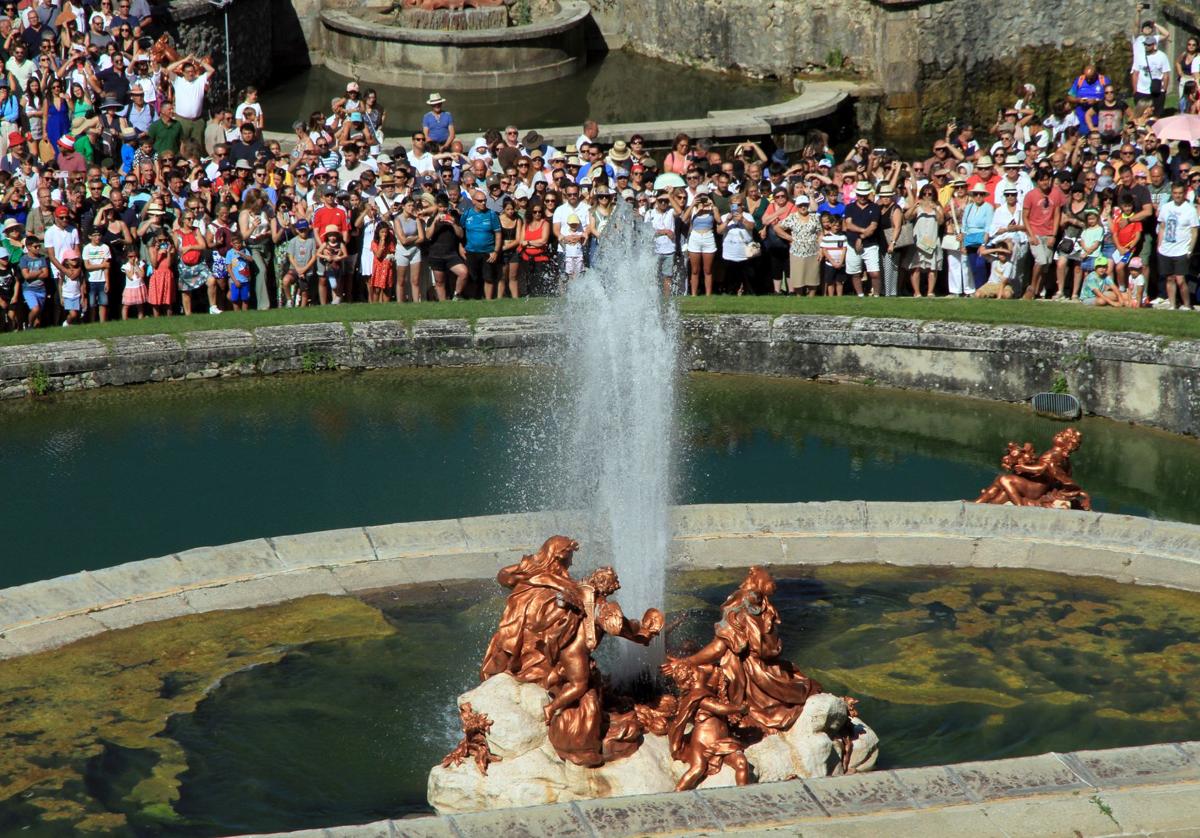 Visitantes admiran el encendido de una de las Fuentes del Palacio Real de La Granja.