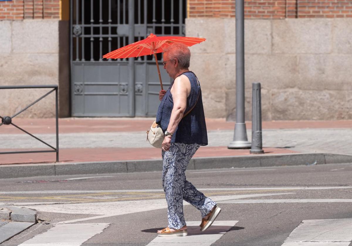 Una mujer se protege del sol en la plaza de España.