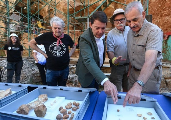 Juan Luis Arsuaga, Alfonso Fernández Mañueco, Eudald Carbonell y José María Bermúdez de Castro observan fósiles extraídos durante esta campaña en Atapuerca.