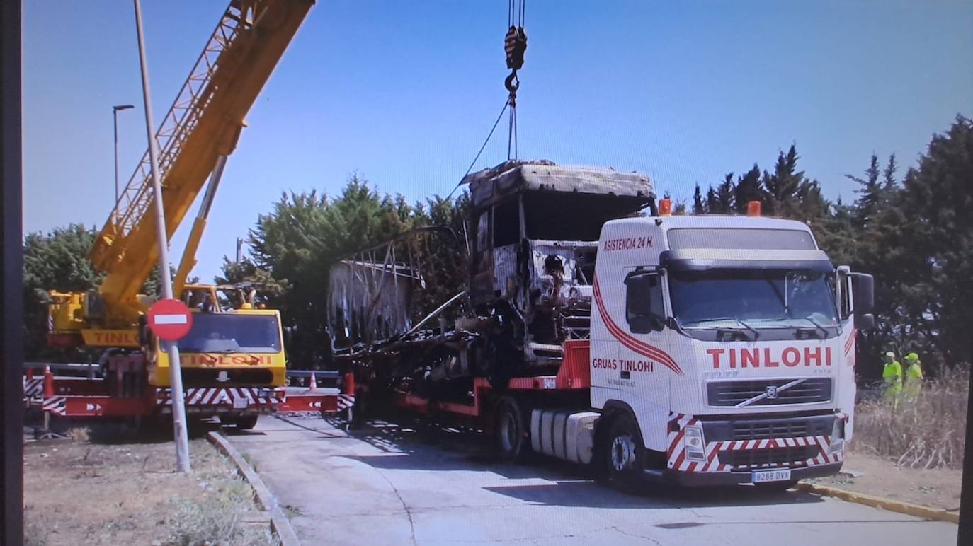 El camión incendiado, retirado por la grúa.