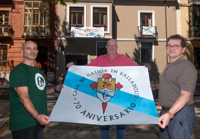 Fernando Martín, Fernando Harguindey y Ernesto Vázquez sujetan la pancarta del aniversario frente a la Casa de Galicia.