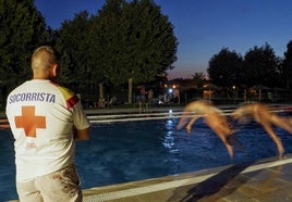 Un socorrista vigila la piscina de Viana, que abre estos días hasta las once de la noche.