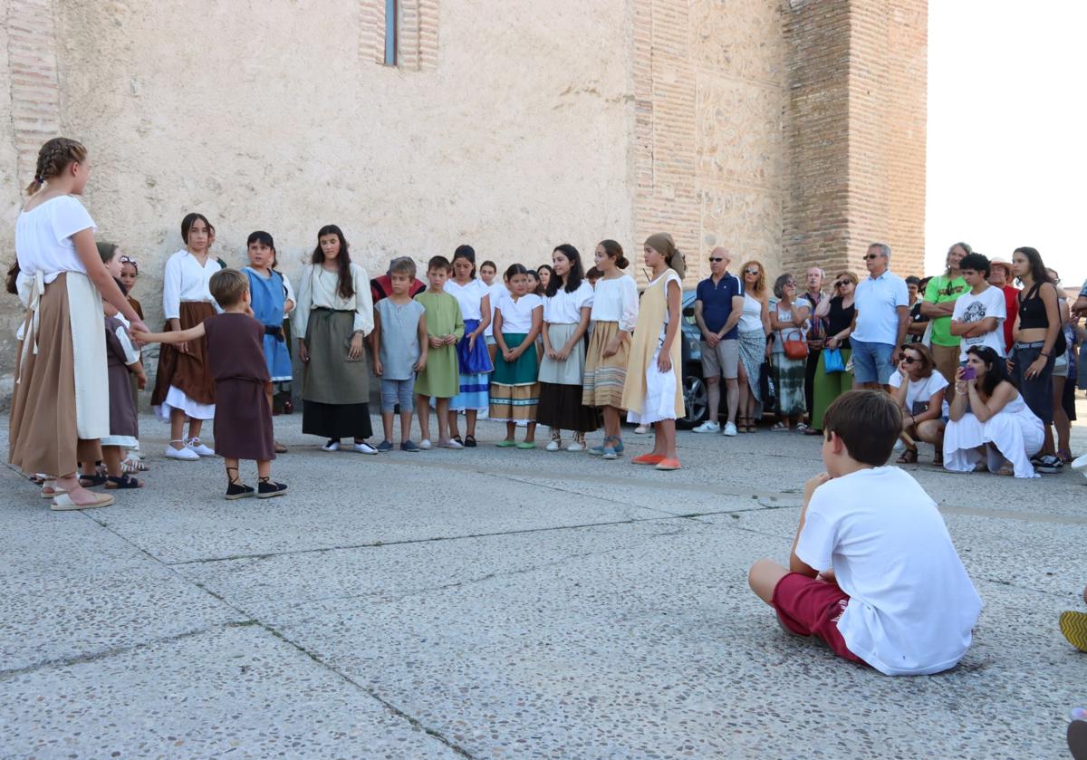 Jóvenes actores representan una obra teatral frente a multitud de visitantes.