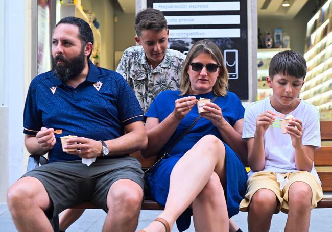 Una familia comparte helados en un banco de la calle Santiago.